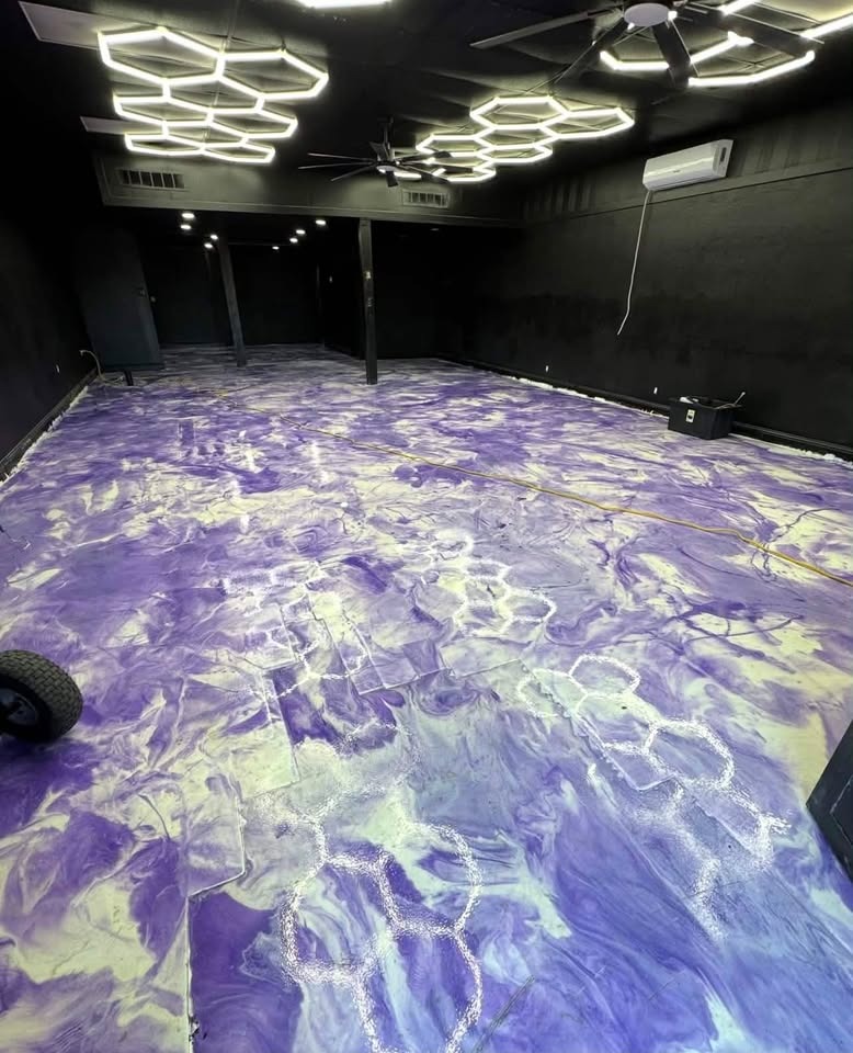 Vibrant purple and white metallic epoxy floor being installed with hexagon LED lights overhead